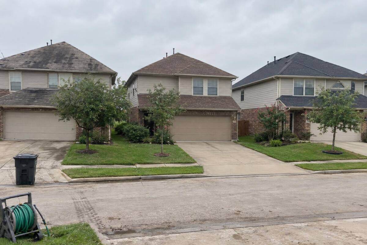 Three neighboring Pearland houses with visibly different roofs: one faded and streaked, one mid-life, one newly shingled